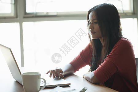 在家里使用笔记本电脑的年轻女性图片