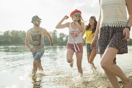 一群年轻朋友在湖中奔跑图片