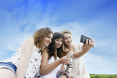3名外地女青年在智能手机上假扮自拍图片