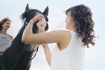 对骑马的年轻妇女低角度观察图片