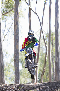 在森林中空跳过的年轻男运动骑手图片