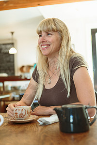 在咖啡馆喝茶的成年女人图片