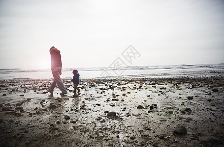男孩和母亲在海滩上散步图片