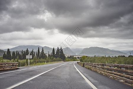 乌云在西班牙马略卡岛穿过乡村景色的空旷道路上面图片