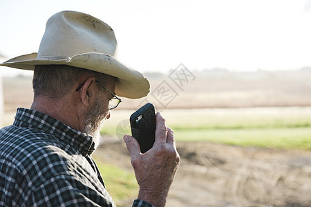 男农民持有智能手机图片