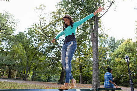 成熟女性在公园栏杆上保持平衡图片