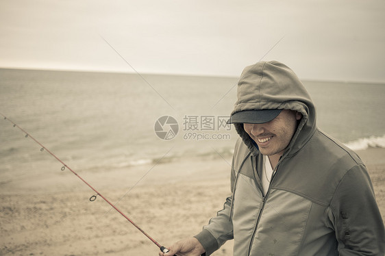 成年男性在海边钓鱼图片