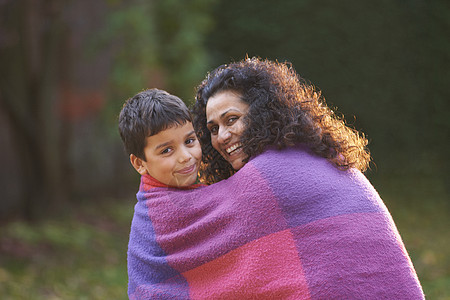在花园里母亲和儿子包着毯子图片