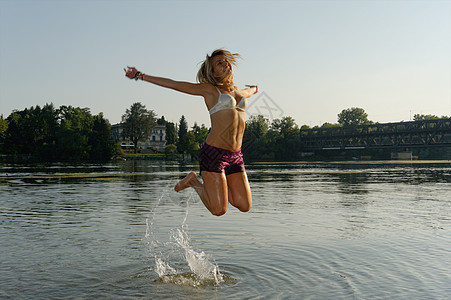 在湖中跳跃的成年女性图片