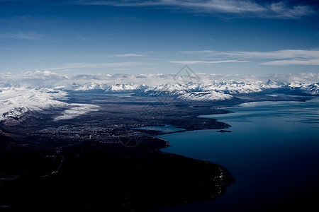 阿根廷火地岛乌斯怀亚市城市海岸线和远处积雪覆盖的山脉鸟瞰图图片