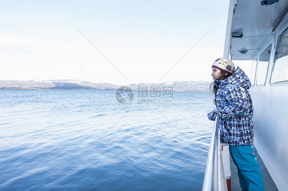 阿根廷火地岛乌斯怀亚一名女孩靠在通往海岸的船上的栏杆上图片