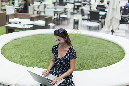 户外咖啡店使用笔记本电脑的妇女图片