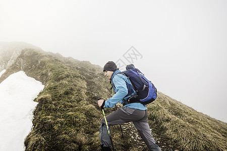 攀登山顶的成年男性图片