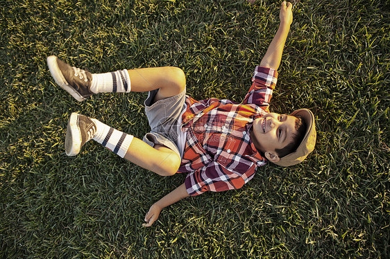 男孩躺在草地上玩耍图片