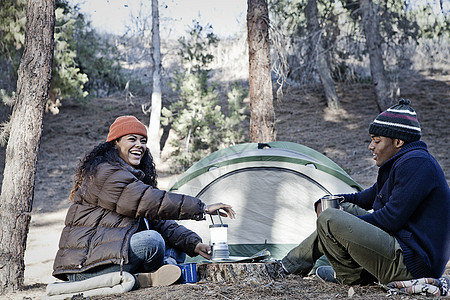 坐在森林中露营的年轻夫妇图片