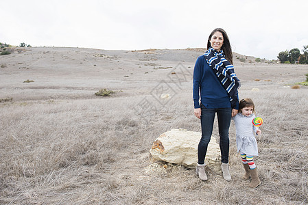 笑着站在山丘前的女人和女儿图片