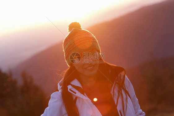 日落时山顶上的年轻女性图片