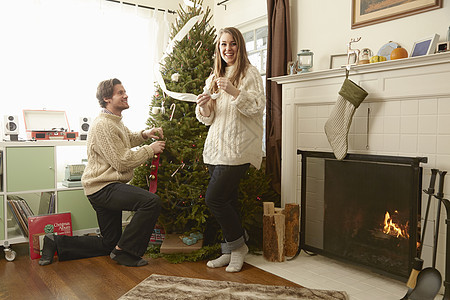 为圣诞树准备圣诞树的年轻夫妇图片
