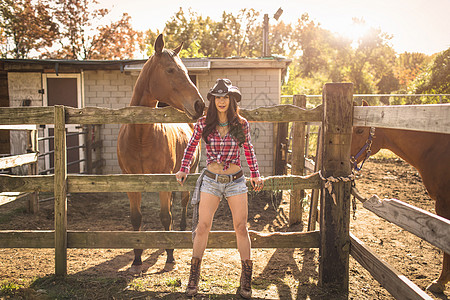 牛仔女孩和牧场上的马匹图片