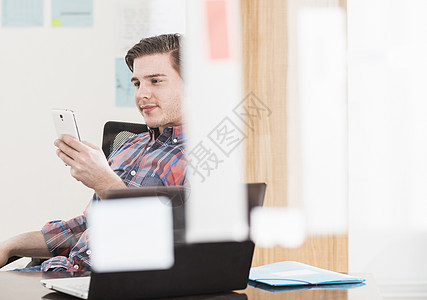 在办公室看手机的青年男性图片