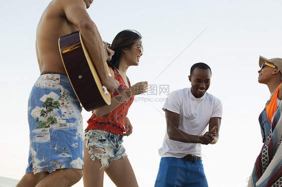 一群朋友在海滩唱歌弹吉他图片