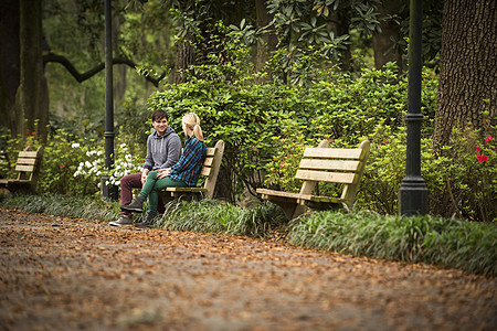 一对情侣在公园长椅上聊天图片