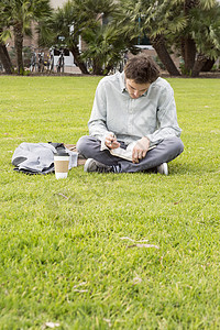 坐在草地上做笔记的商人背景图片