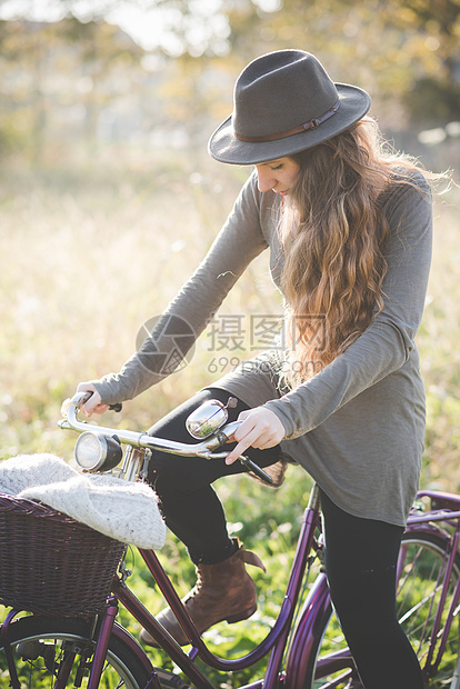 戴着帽子骑自行车的年轻女性图片