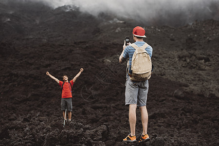 在危地马拉安提瓜火山拍摄朋友照片的年轻人图片