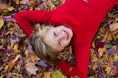 女孩躺在秋叶上的肖像图片