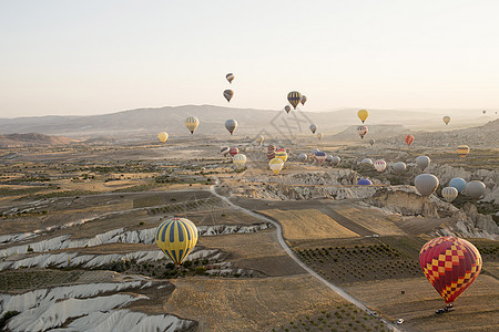 土耳其安纳托利亚卡帕多西亚一大群热气球漂浮在田野景观上图片