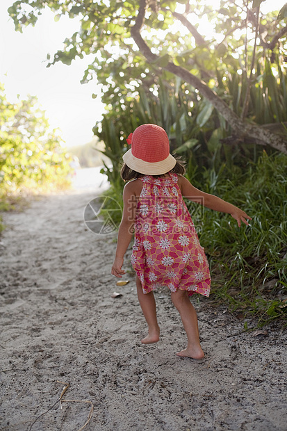 戴着太阳帽的赤脚女孩在林地海滩小路上行走图片