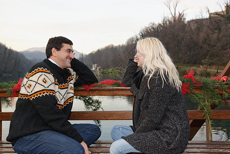 意大利伦巴迪湖边异恋夫妇面对地坐在长椅上对面的异恋夫妇图片素材