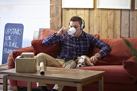 中年男子在照片设计师展厅喝咖啡和宠狗图片