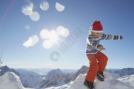 年青男孩站在积雪上地的风景下图片