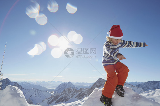 年青男孩站在积雪上地的风景下图片