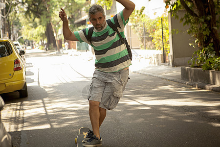 巴西里约热内卢街上骑滑板的成年男子图片