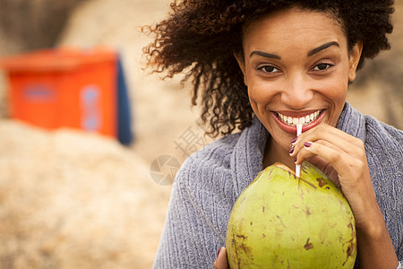 巴西里约热内卢伊帕马海滩上年轻妇女喝椰子奶的肖像图片