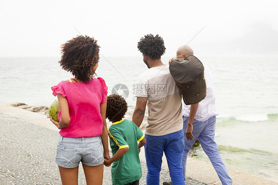四人沿巴西里约热内卢伊帕马海滩漫步的四人家庭近视图片