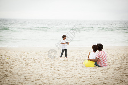 夫妻和儿子在海滩上拍照图片