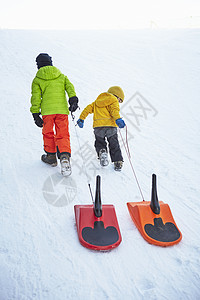 男孩在雪地里拉雪橇车图片