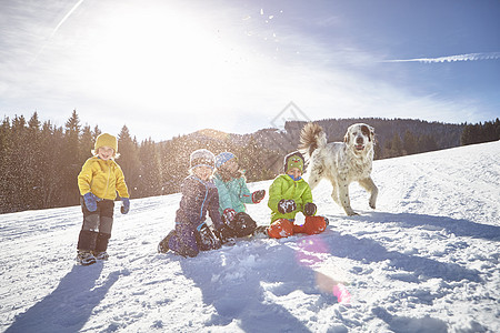 狗玩耍享受在雪中玩耍的儿童和狗狗背景