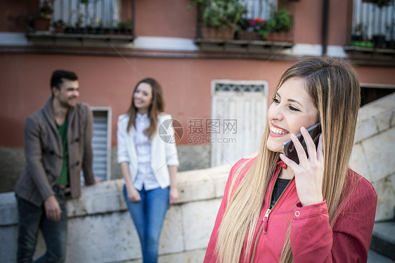 街上使用智能手机打电话的年轻女性图片