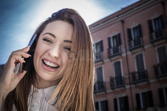 街上使用智能手机打电话的年轻女性图片