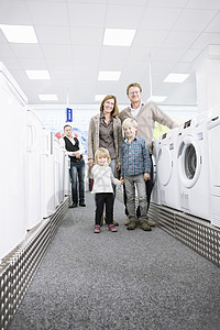 带两个孩子的夫妇在商店挑选洗衣机图片