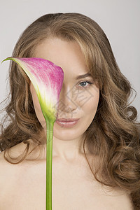 年轻女当面拿着花朵的肖像高清图片