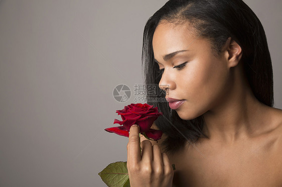 年轻女人面对着红玫瑰的肖像图片