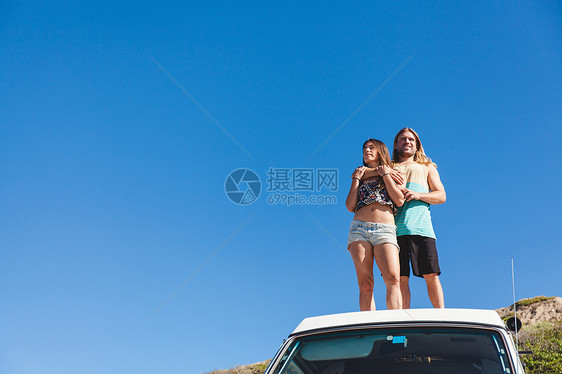 情侣抱着站在野营车的顶上图片