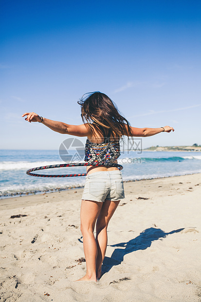 女人在海滩上转呼啦圈图片