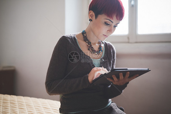 在家里使用数字平板电脑的年轻妇女图片